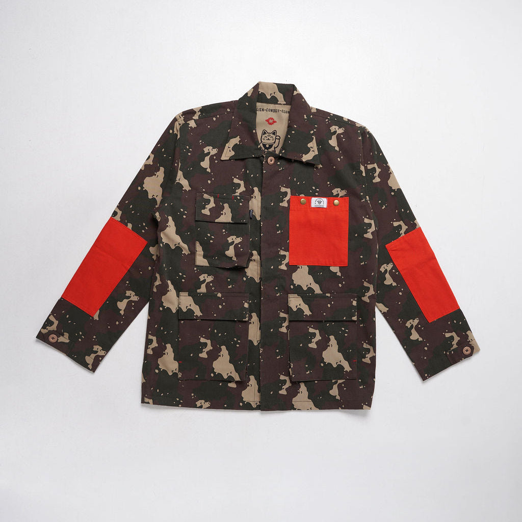 Camouflage jacket with red patches on a white background